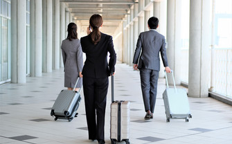 Three people with suitcases on a business trip