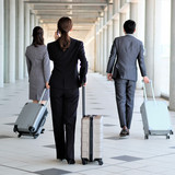 Three people with suitcases on a business trip