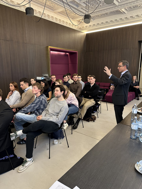 [Translate to English:] Niklas Schmidt talks as he moves through the room