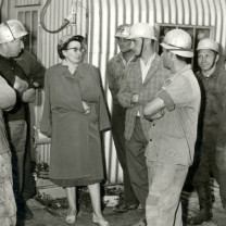 Margarethe Ottillinger mit Arbeitern, die Helme tragen